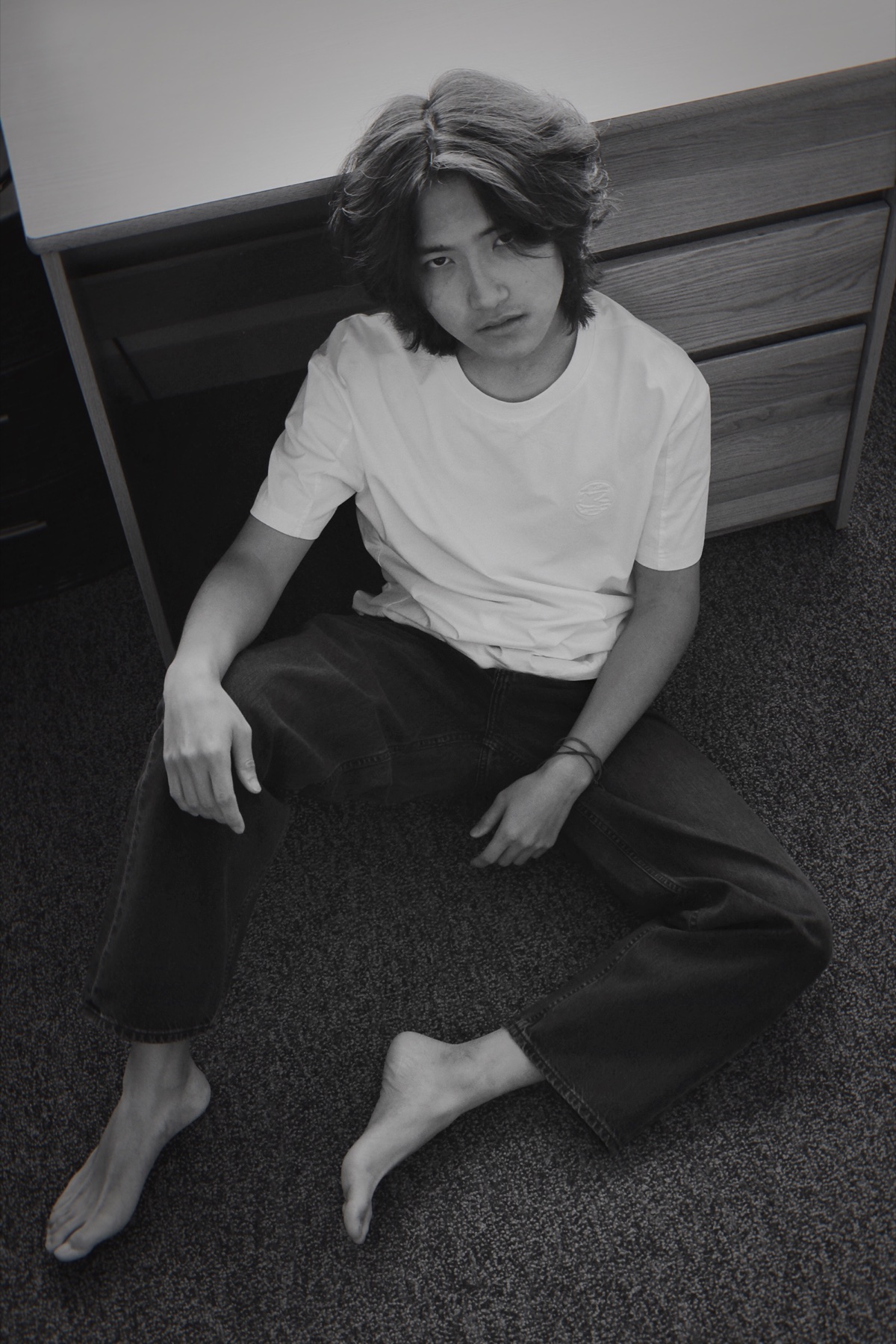 Black-and-white seated portrait of Jerry Pan looking up toward camera