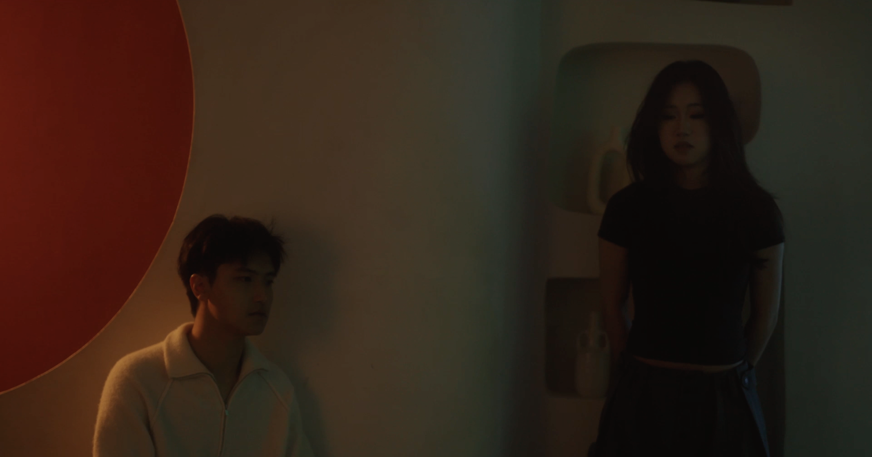 Inner Space still of Jerry Pan seated beside another performer in a dim interior