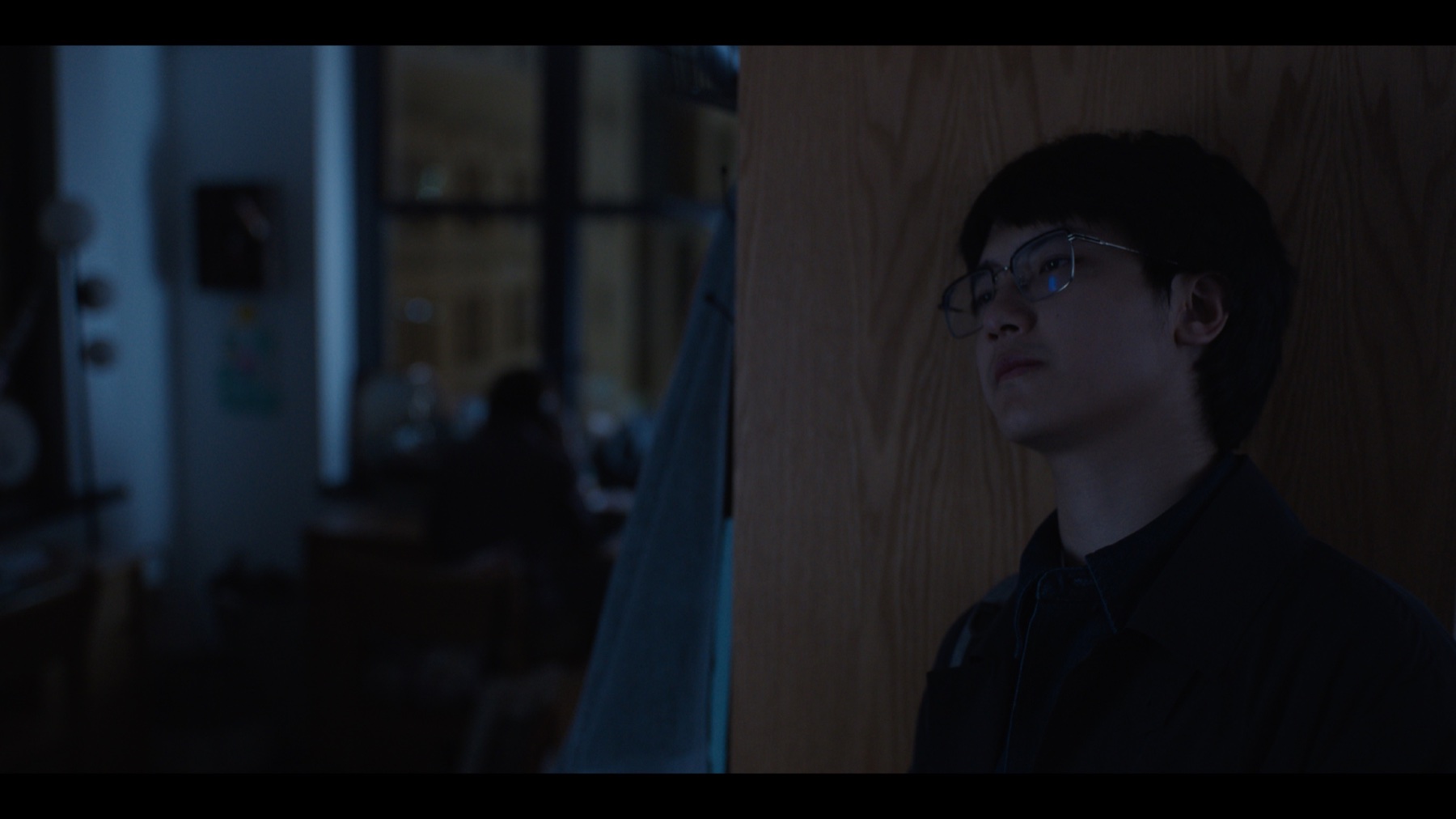 Blue-toned Once Upon the Time in Boston still of Jerry Pan standing in a dim interior